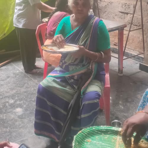 An elderly woman eating her meal