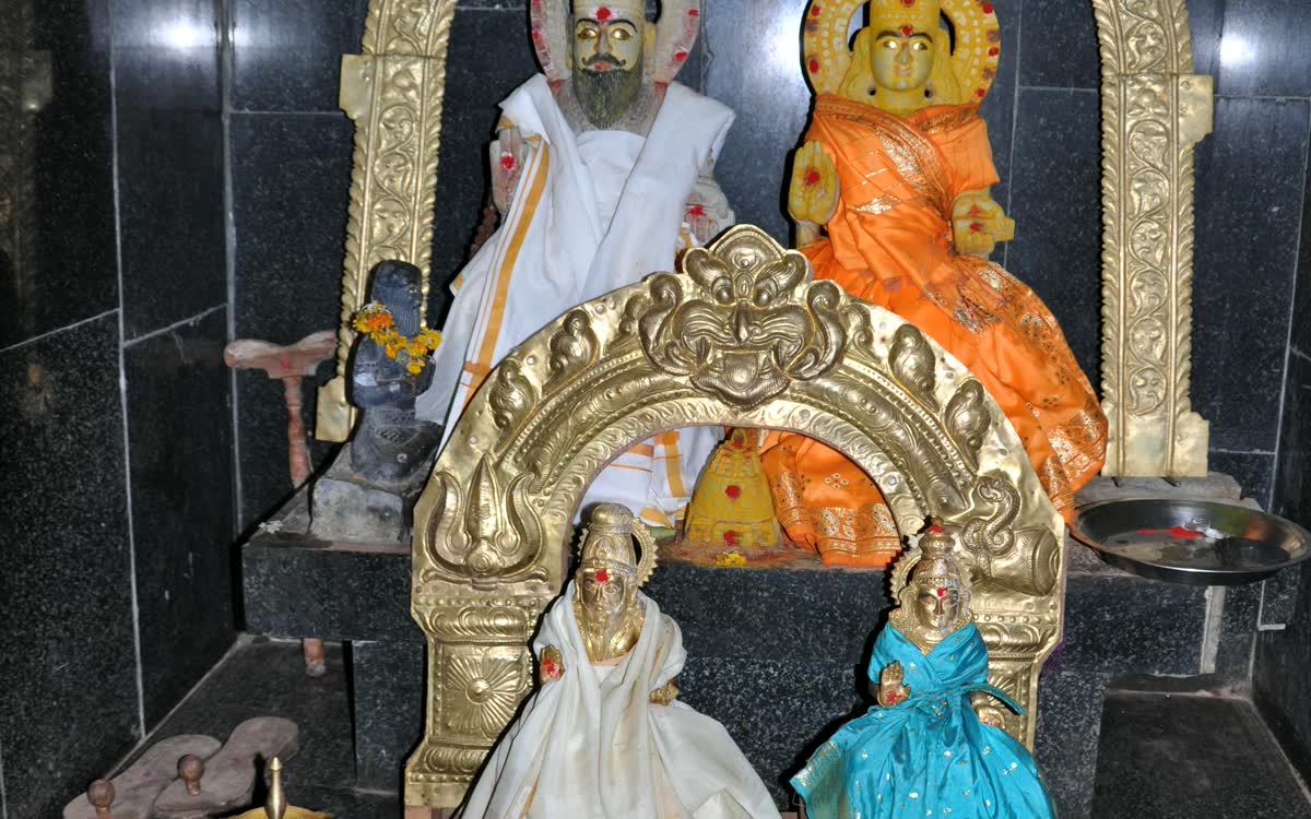 Idols in a black granite sanctum with brass lamps before them