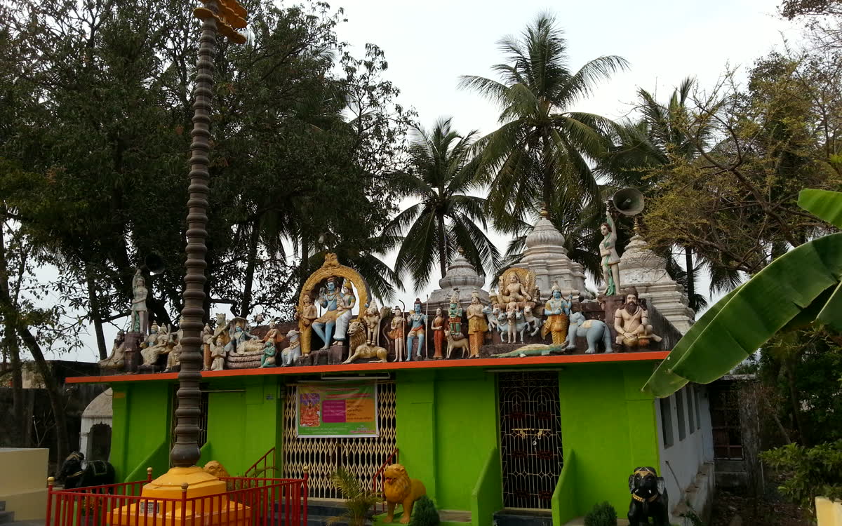 Rows of small shrines along the roof of the matam, palms behind
