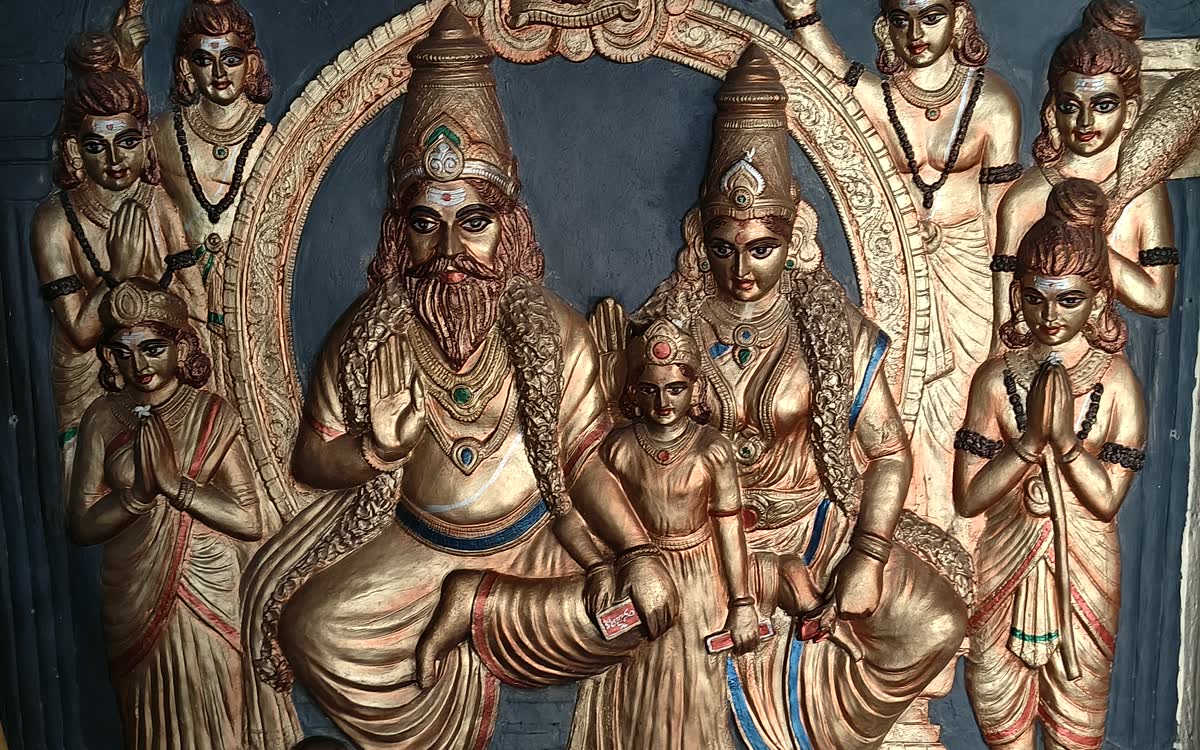 A carved relief of the Swamy enthroned with Govindamma, attendants on either side